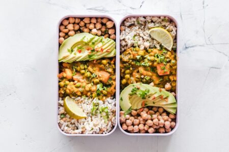 A school-style lunch of rice, chickpeas and vegetable curry in two lunch boxes
