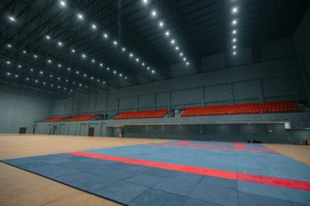 Blue and red martial arts training mats in a large indoor sports hall